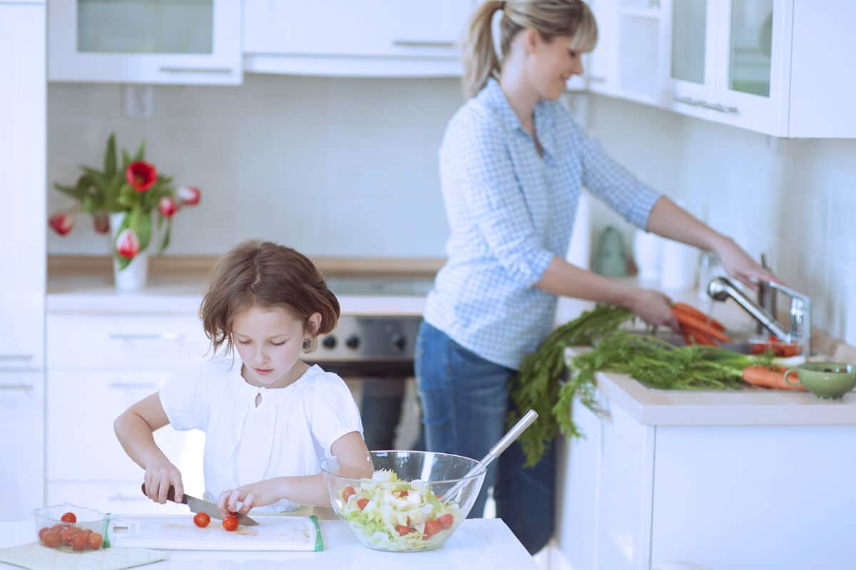 Mutter und Kind bereiten Essen in der Küche zu
